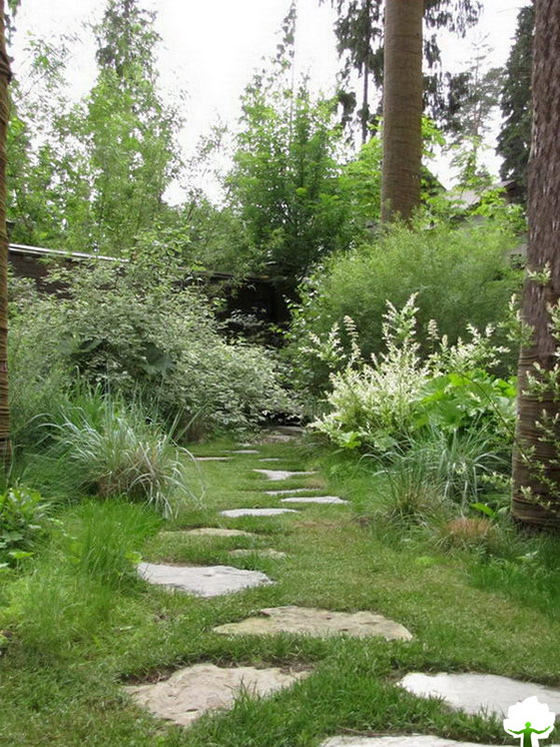 Пошаговая дорожка из натурального камня прекрасно вписывается в свободную планировку небольшого сада.